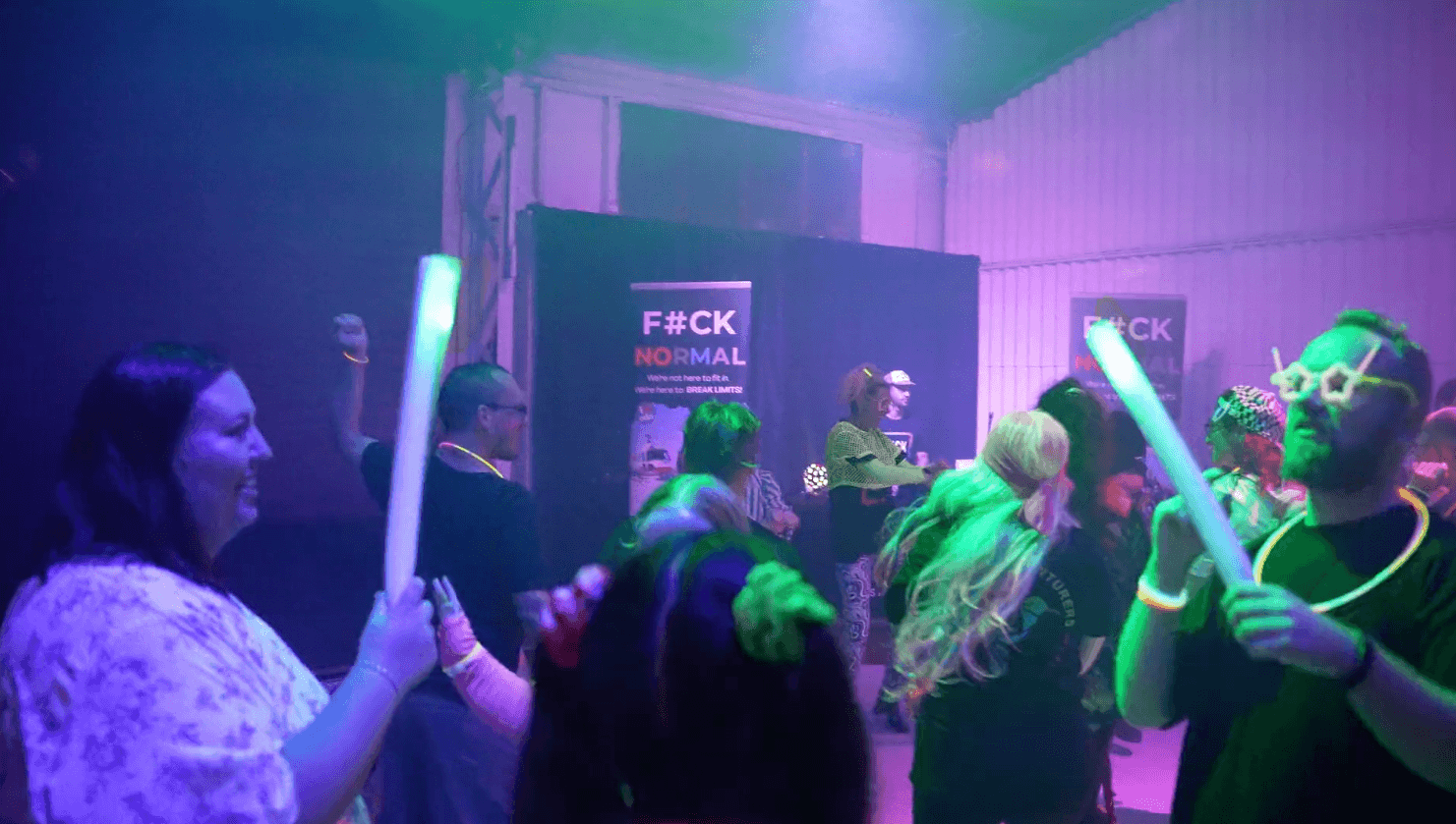 The crowd waving glow sticks on the dance floor at Freedom's neon party